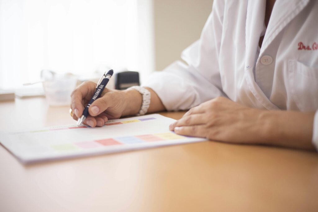 Rapport final Close-up of a female doctor writing a prescription at a desk in an office setting.